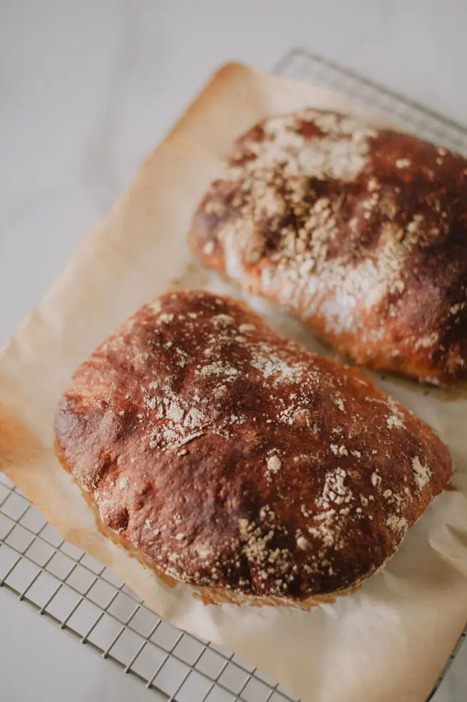 http://curiousbaking.com/wp-content/uploads/2023/04/Two-loaves-of-bread-sitting-on-top-of-a-cooling-rack.jpg.webp