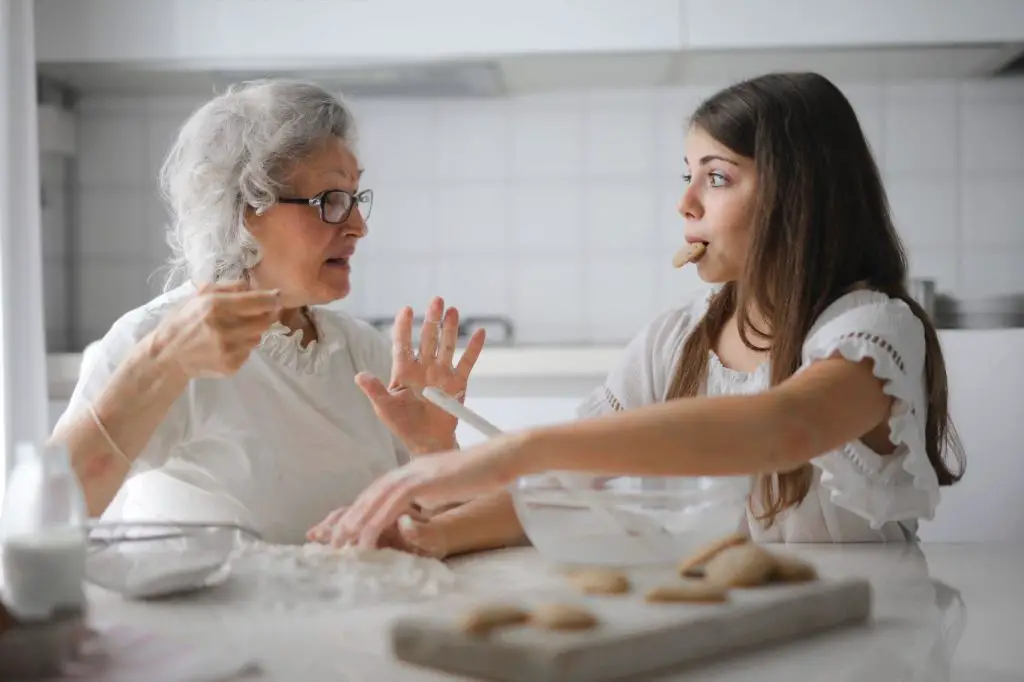 Grandma is giving baking tips to her grandchild